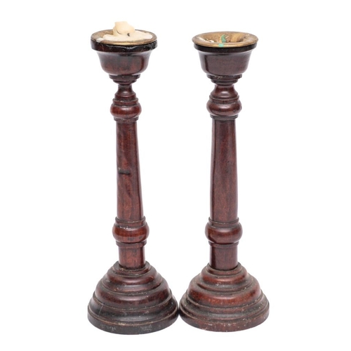 348 - A pair of mahogany candlesticks: with brass sconces, turned stems and mound bases, 31cm high, 19th C... 