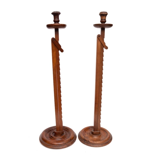 349 - Two walnut adjustable candle stands:, the circular sconces with adjustable ratcheted stems and circu... 