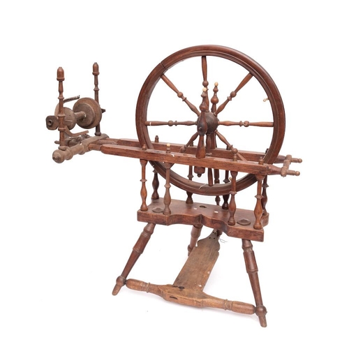 428 - A 19th Century beechwood spinning wheel: with turned spindle spokes, baluster turned uprights and tr... 