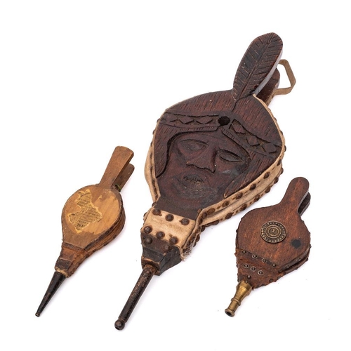 438 - A set of carved wood and suede leather bellows:, decorated with a face, also two small bellows; one ... 