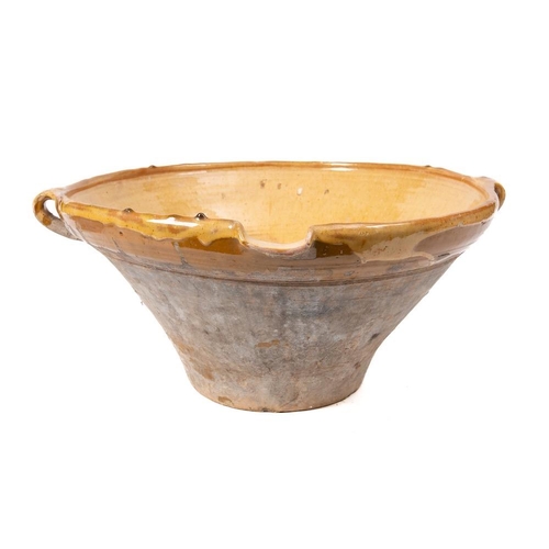 479 - A terracotta, yellow and ochre slip glazed single lipped circular dairy bowl:, 48cm diameter.