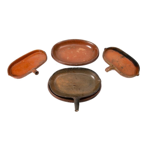 480 - A terracotta and slip glazed oval fat catcher: with single handle and lipped bowl, 33cm long, two ot... 