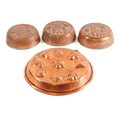 49 - A circular copper mould: with raised decoration of shells, 28cm diameter, also three circular tinned... 