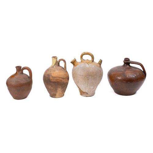 501 - A stoneware olive oil jug: with three handles and raised decoration, a terra cotta wine ewer and thr... 