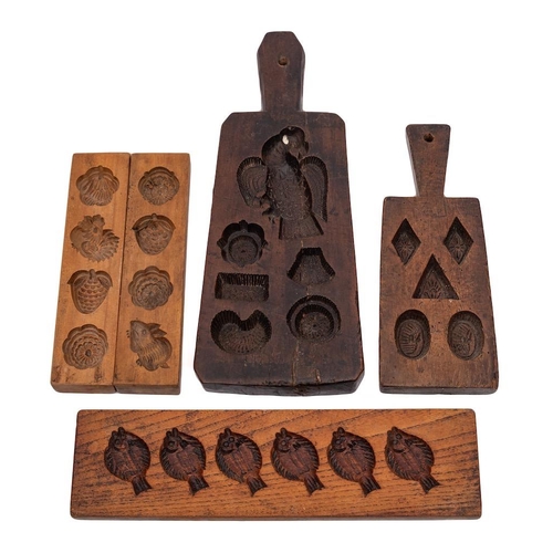 55 - Four various treen chocolate moulds:, two with handles and one being decorated with fish.