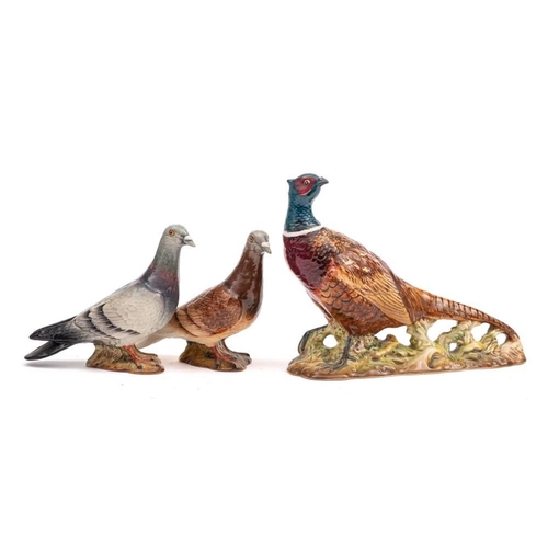 18 - Three Beswick birds: comprising two pigeons, second version under blue and red gloss and a pheasant,... 