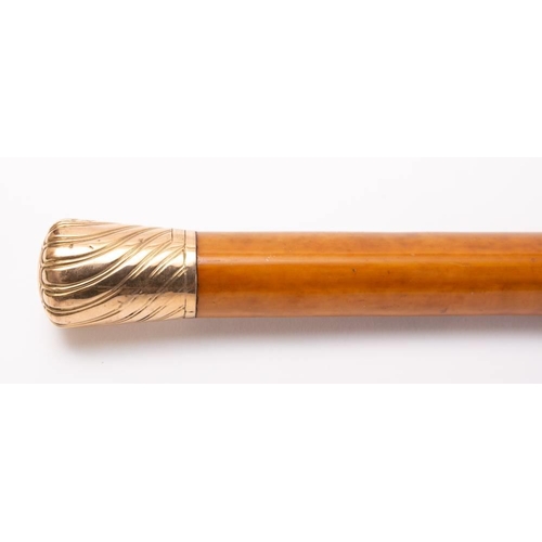 85 - An early 20th century 9ct gold mounted walking cane, London 1914,: the Malacca shaft with leather fe... 