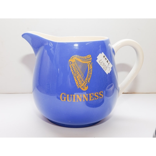 25 - A group of five Guinness advertising ashtrays: together with a blue glaze Guinness water jug and a w... 