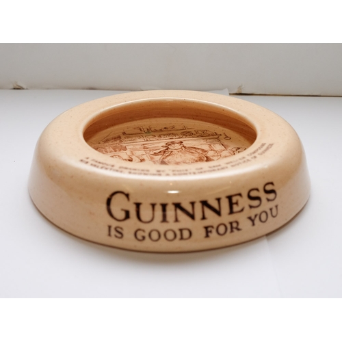 25 - A group of five Guinness advertising ashtrays: together with a blue glaze Guinness water jug and a w... 