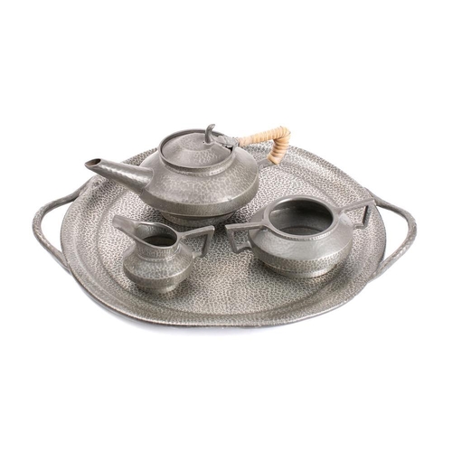 422A - An Arts & Craft influence pewter three-piece tea service: together with circular serving tray with l... 