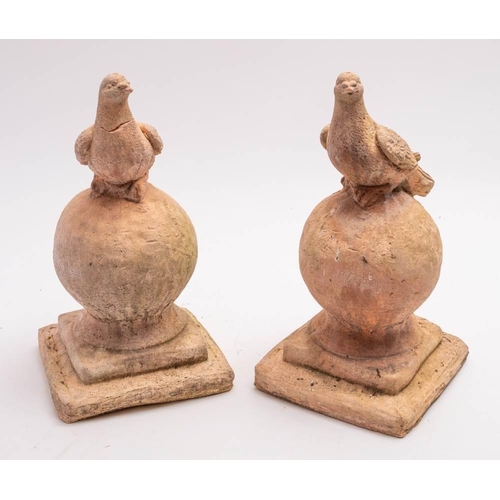 123 - A pair of late 19th/early 20th century terracotta roof finials in the form of a dove resting on a ba... 