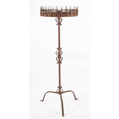 131 - A late 19th/early 20th century wrought iron pricket stand: the central sconce with a  circular board... 