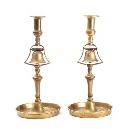 139 - A pair of 19th century brass tavern service candlesticks: the plain sconces over a lever operated be... 