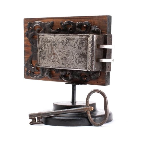 253 - A 17th century French steel engraved rim lock with key:  double angled bolts within a case with  pol... 