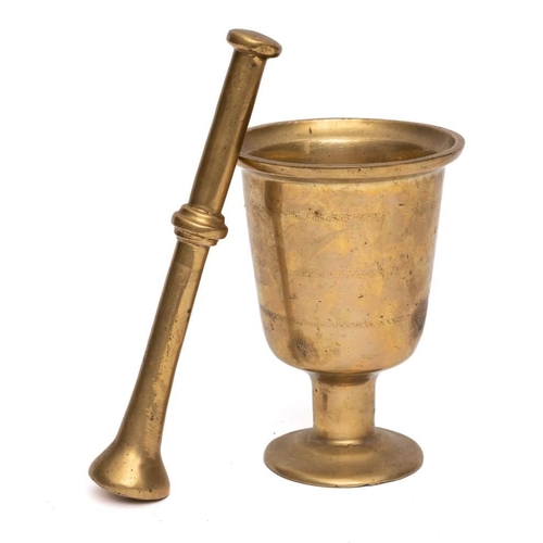 51A - A brass mortar: of chalice shape, on circular foot, 21cm high, together with a brass pestle.