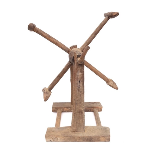 60 - A rustic hoist:, the four spurs operated by a shaped handle, on a trestle base, 37cm across.