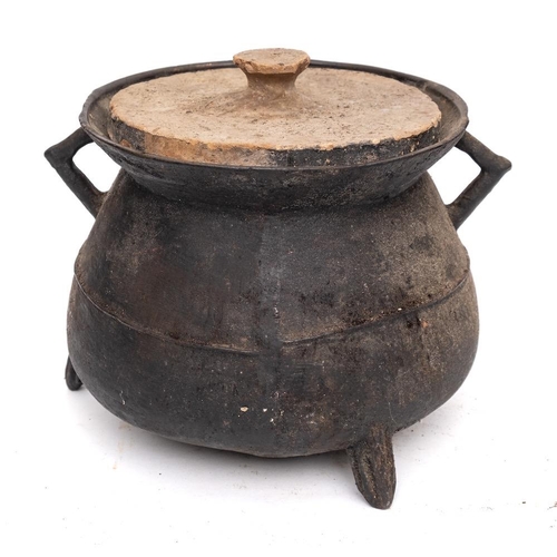 84 - A bronze twin-handled cauldron: of traditional bag shape with angular handles, on tripod splayed fee... 