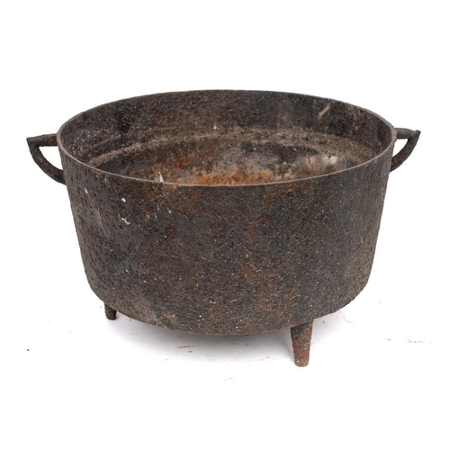 85 - An iron circular open cooking pot: with twin angular handles and tripod feet, 28cm diameter, 17th/18... 