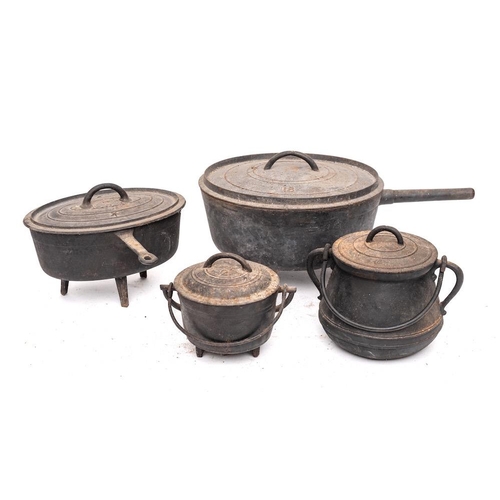 86 - A circular iron cooking pot and cover: on tripod feet, 32cm diameter, another oval with cover, 27cm,... 