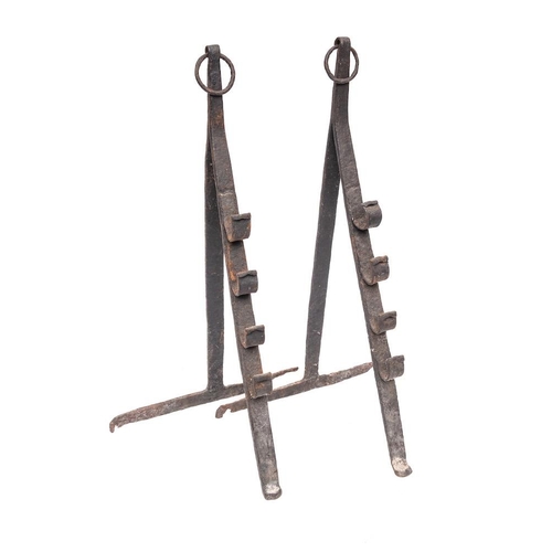 99 - A pair of wrought iron spit dogs: of easel type with ring finials, with hook for four heights, 59cm ... 