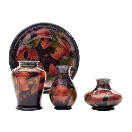 168 - Three Moorcroft vases and a plate each tube lined in the Pomegranate pattern in red, purple, green a... 