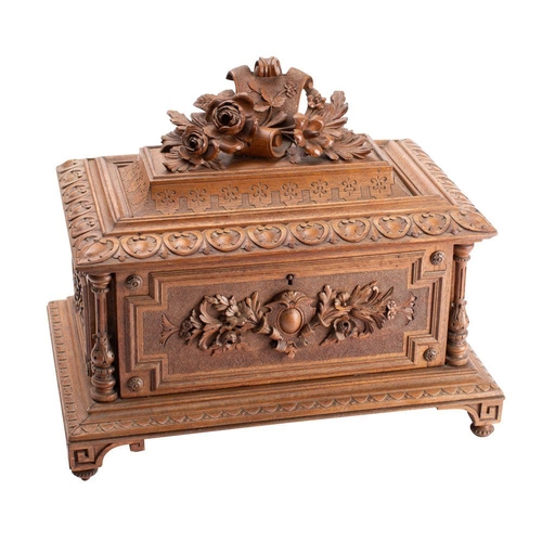 355A - A Black Forest carved linden wood casket of rectangular outline, the domed hinged lid with floral ca... 