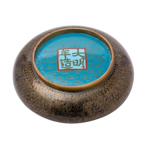 407 - A Chinese cloisonne bowl centred with the emblem for longevity with coiled scale decoration to a bla... 