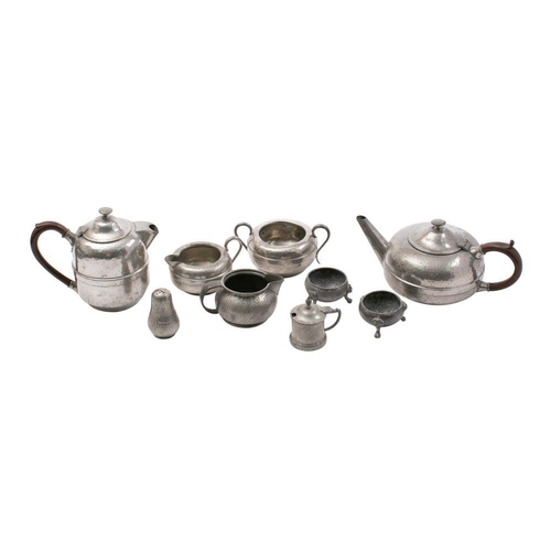 523 - A beaten pewter four-piece tea set, includes a tea pot,  hot water jug, cream jug and sugar basin, a... 