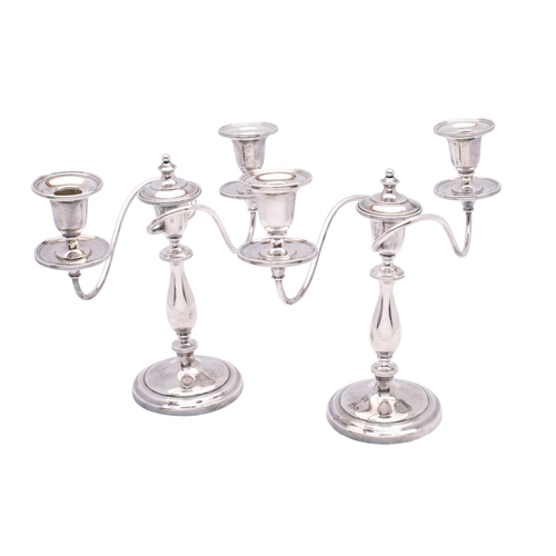 2041 - A pair of silver plated twin branch candelabra with scrolling branches terminating in urn-shaped sco... 