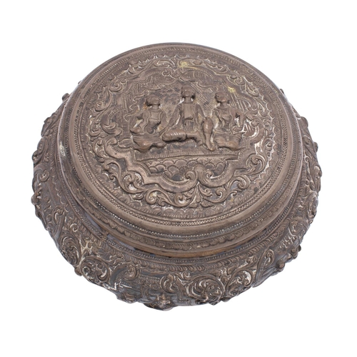 2109 - A Burmese silver jar and cover of circular form with repousse decoration of figures in interiors, on... 