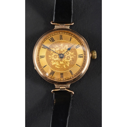 2374 - A 9ct gold wristwatch, the gilded dial with Roman numerals on engraved floral background, with blue ... 