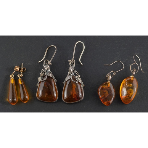 2514 - Three pairs of amber drop earrings, including a pair with foliate mounts and hook fittings; a pair  ... 