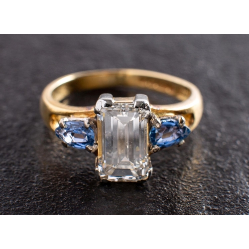 2974 - An 18ct gold, octagonal, step-cut diamond and pear-shaped sapphire three-stone ring, estimated diamo... 