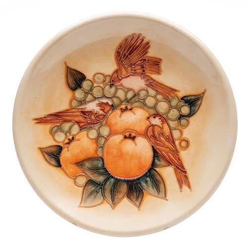 198 - A John Moorcroft pottery plate, tube lined in the Finches pattern on a peach ground, printed and pai... 