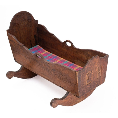 843 - An early 20th century Danish oak crib, carved and dated '13 Oktober 1902', raised on sleigh rockers,... 