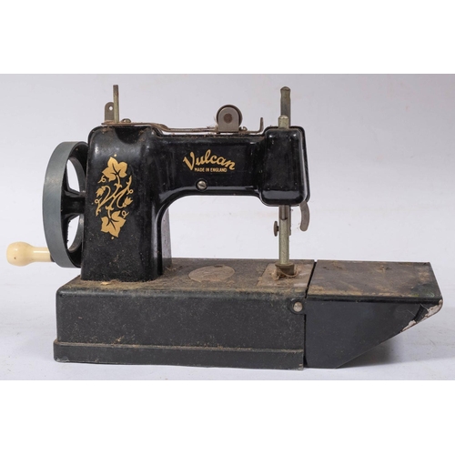 1215 - A Vulcan Tinplate toy sewing machine with remains of original box and a small trunk case.