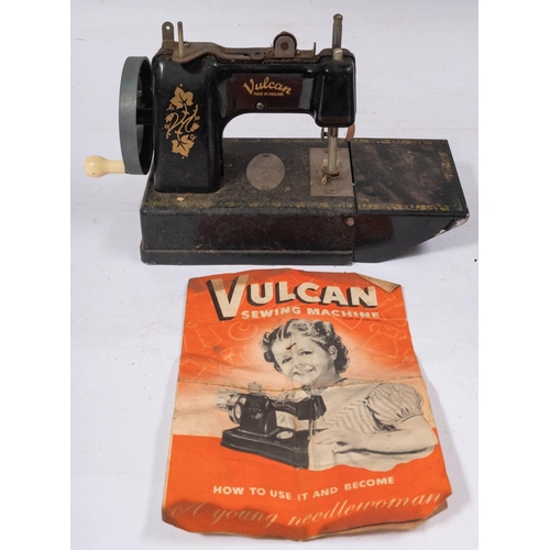 1215 - A Vulcan Tinplate toy sewing machine with remains of original box and a small trunk case.