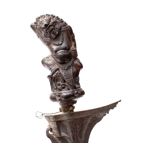 194 - A Balinese ornamental Kris, the shaped double edge Damascus blade over a carved figural grip togethe... 