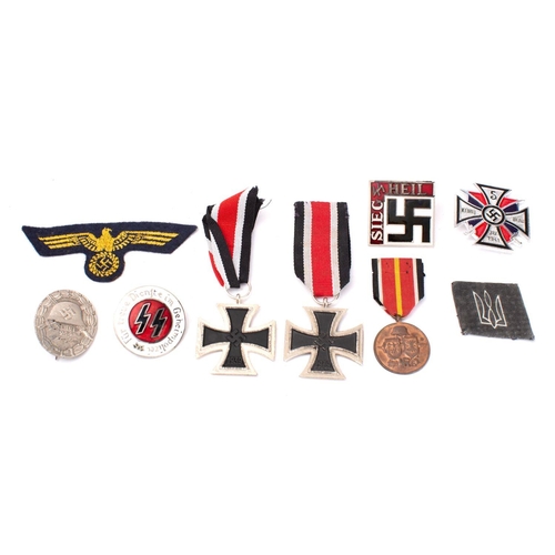 294 - A small collection of reproduction German military medals and badges.