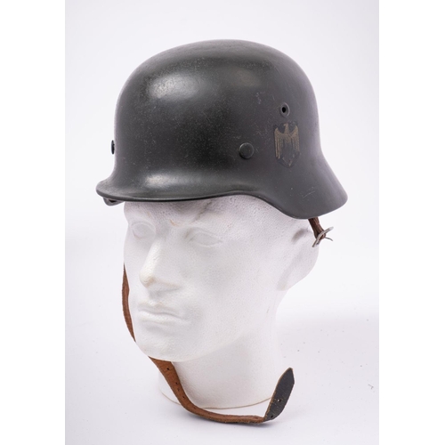 331 - A German M1942 pattern Stahlhelm,  dark green with remains of transfer to one side, brown leather li... 