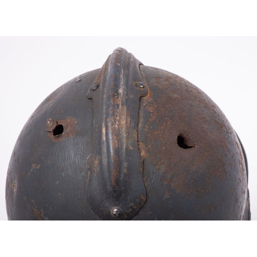 334 - A WWI French Artillery M15 Adrian steel helmet of three piece construction with comb and 'RF' helmet... 