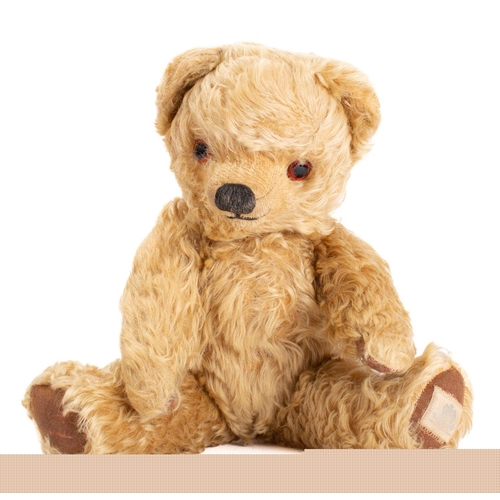 860 - A Merrythought blonde plush Teddy bear with glass eyes, stitched nose and mouth, over a jointed body... 