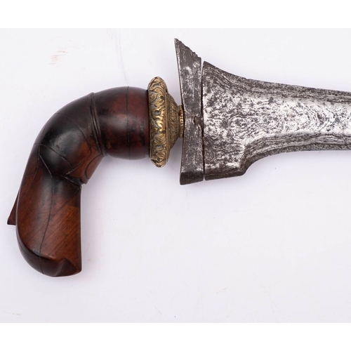 223 - An Indonesian kris, the straight double edged Damascus blade over a gilt brass circular floral cast ... 