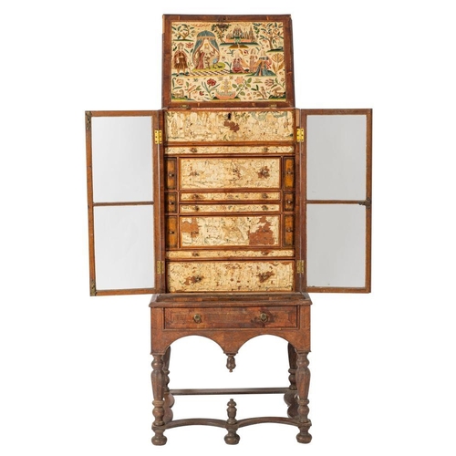 998 - A walnut and embroidery adorned cabinet on stand, elements 17th century and later; the hinged top an... 