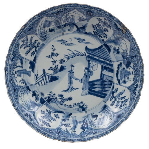 106 - A Chinese blue and white lotus moulded dish painted with two ladies in a garden by a pavilion within... 