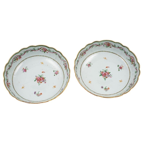 110 - A pair of Chinese famille rose shallow bowls with lobed foliate rims, each painted with scattered fl... 