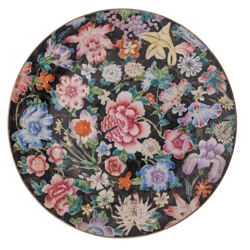 118 - A pair of Chinese famille noire millefleurs plates painted with brightly coloured blooms on a black ... 