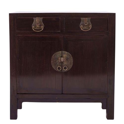 1352 - A Chinese stained hardwood cupboard, 20th century; the twin short drawers each with brass swing hand... 