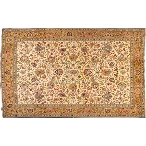 1365 - A Tabriz Carpet:, the ivory field with an all over design of palmettes and scrolling lanceolate leav... 