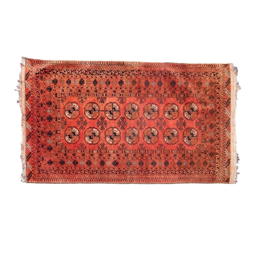 1371 - A Turkoman rug, the brick red field with two rows of quartered medallions, enclosed by a shaded bote... 